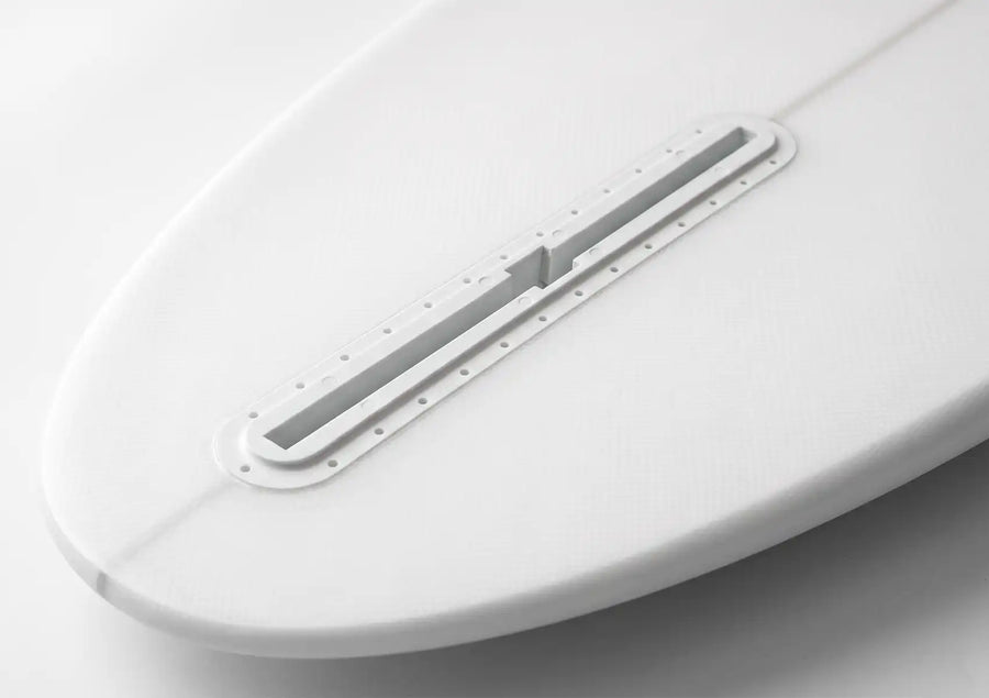 A fin box glassed into a surfboard tail